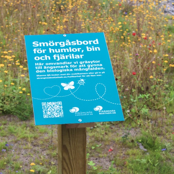 Skylt vid en ängsmark.