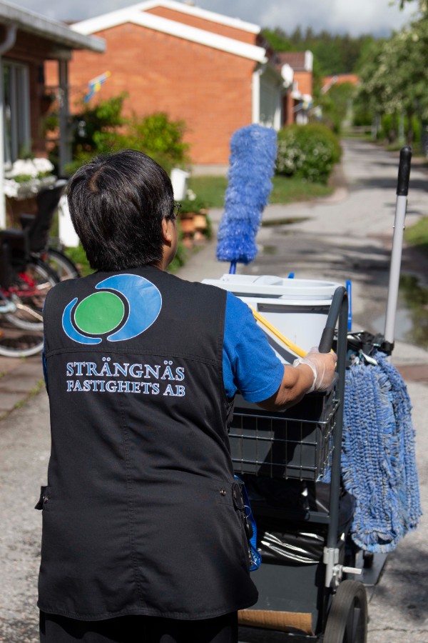 Lokalvårdare med Strängnäs Fastighets ABs logotyp på ryggen.
